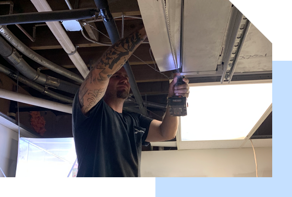 A man is working on a ceiling in a room, providing Maui HVAC services.