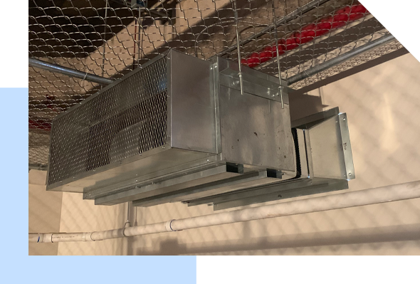 An air conditioning unit hanging from a chain link fence, offering Maui HVAC services.