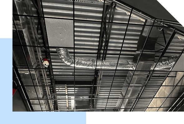 A black and white photo of a metal ceiling in a building featuring Strategic Air Conditioning.