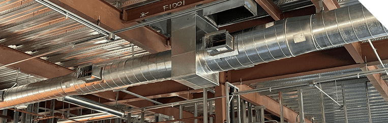 Industrial building with metal pipes for ductwork and Maui HVAC services.